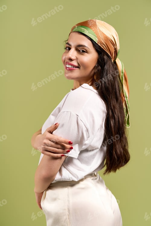 Preview: Stylish young woman embraces summer fashion with vibrant headscarf in green studio