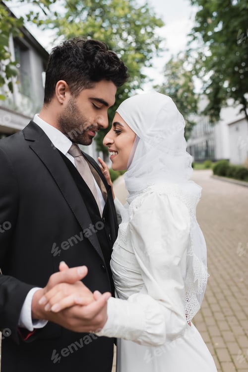 Preview: Happy Muslim Bride and Groom With Closed Eyes Holding Hands