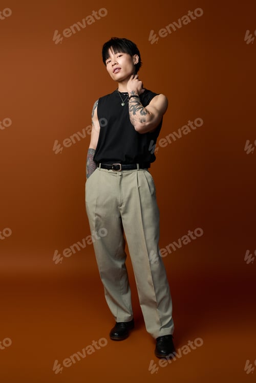 Preview: Stylish young man poses confidently against a warm, earthy backdrop in casual fashion