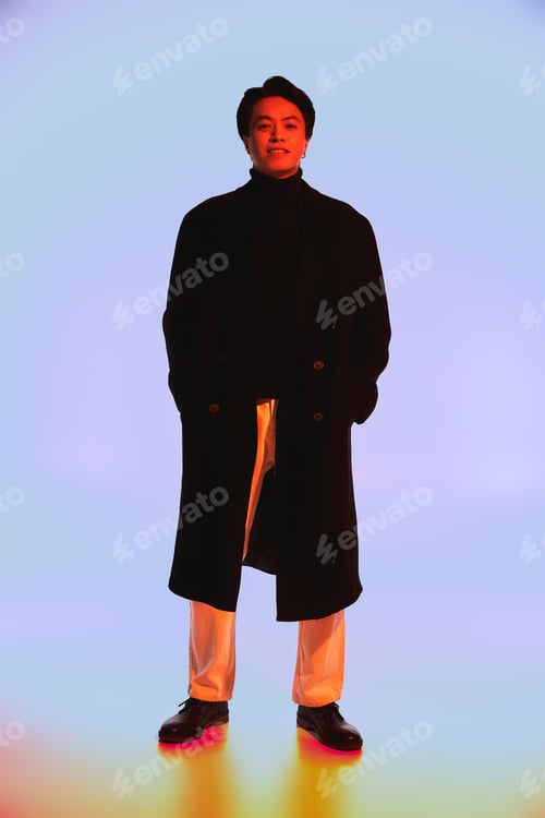 Preview: Stylish young asian man expressing vibrant fashion sense in a creative studio setting