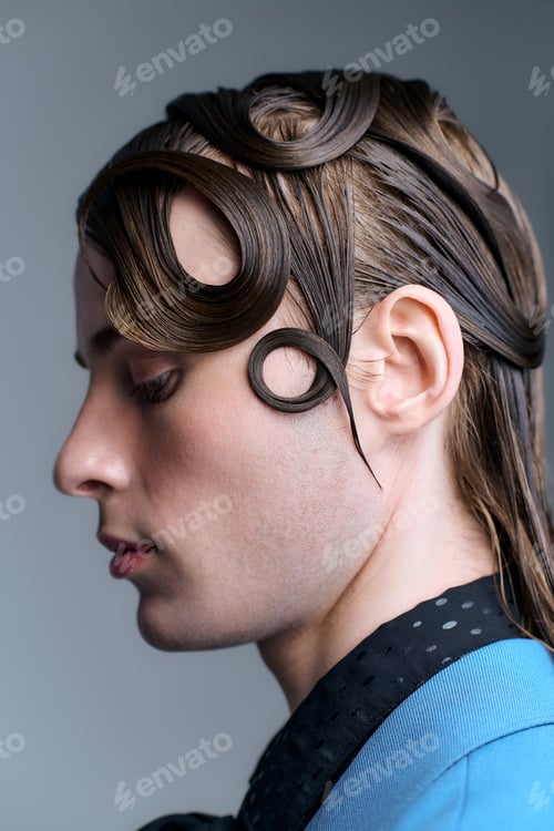 Preview: Young man showcases modern fashion and stylish hair design in creative studio setting