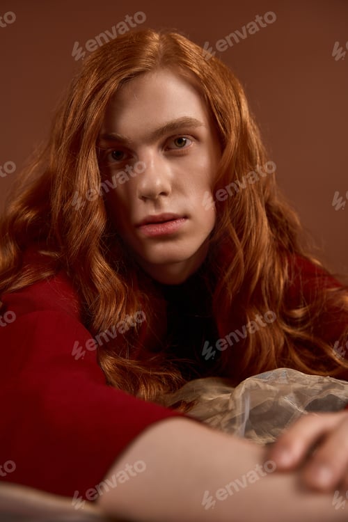 Preview: Elegant young man with flowing red hair showcases style and grace in a serene setting