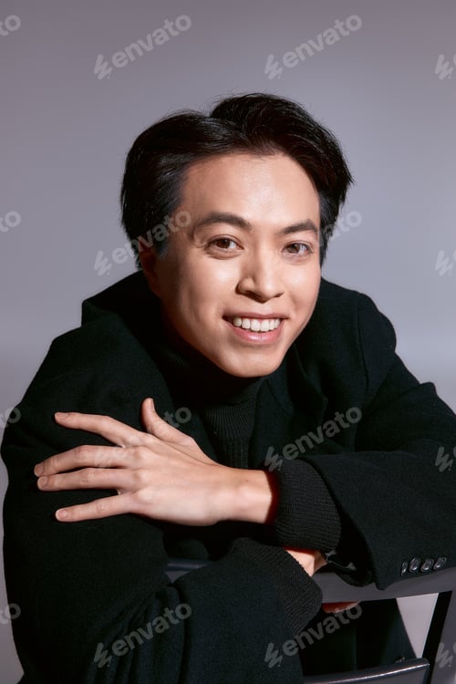 Preview: Stylish young man in a trendy outfit exuding confidence in a modern studio setting