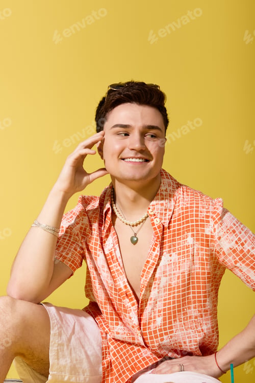 Preview: Stylish young man enjoying summer vibes with a cheerful smile and trendy outfit