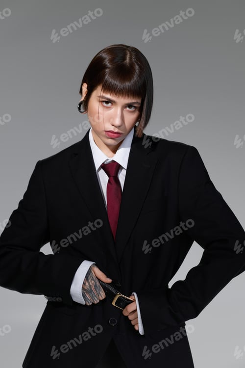 Preview: Stylish young woman showcases contemporary fashion in elegant black suit and trendy accessories