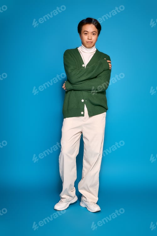 Preview: Stylish asian young man embraces modern fashion in a vibrant studio setting