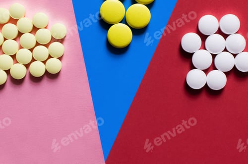 Preview: Top View of Round Shape White and Yellow Pills on Colorful Background