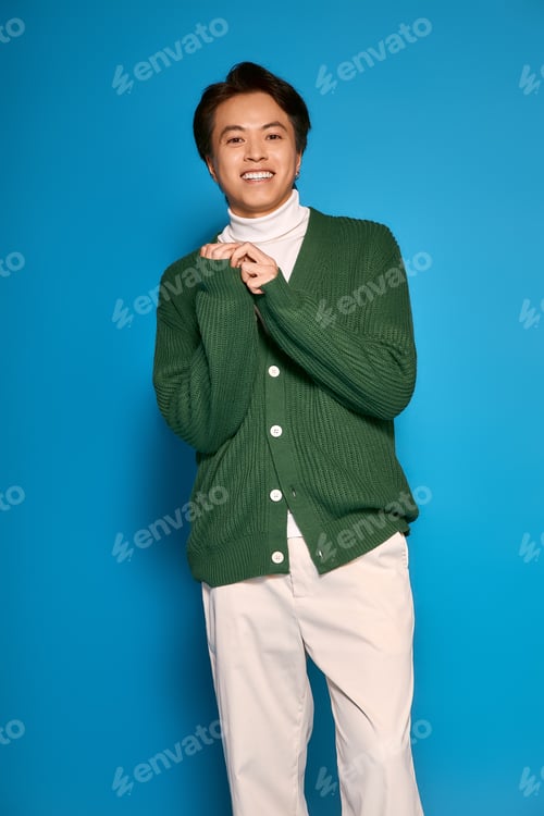 Preview: Stylish asian young man showcases vibrant fashion in a creative studio setting