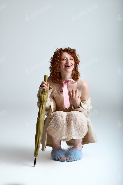Preview: Stylish young woman enjoying a moment of joy with an umbrella in a light, airy space