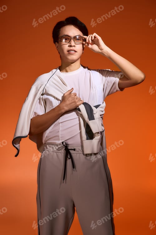Preview: Fashion forward young man displays unique style in vibrant studio setting