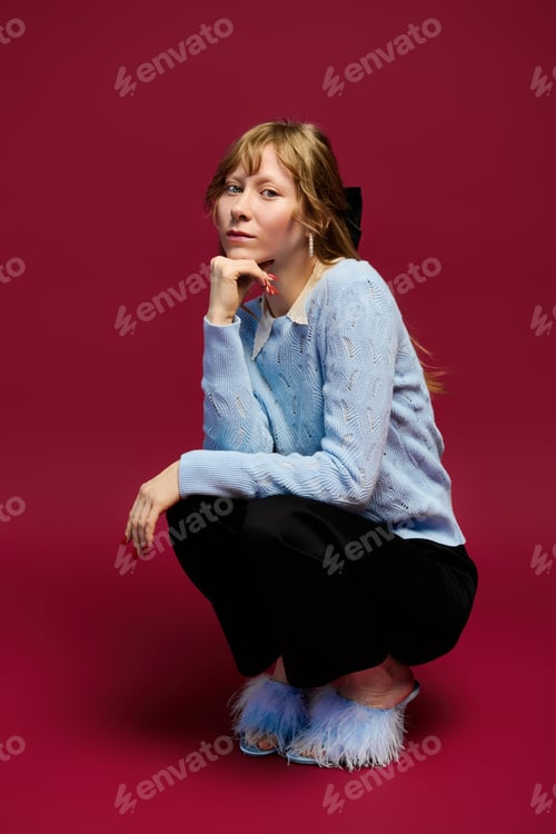 Preview: Elegant young woman in stylish attire poses gracefully against a vibrant backdrop