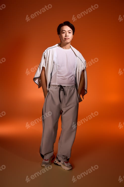 Preview: Stylish young man showcasing modern fashion in a creative studio setting