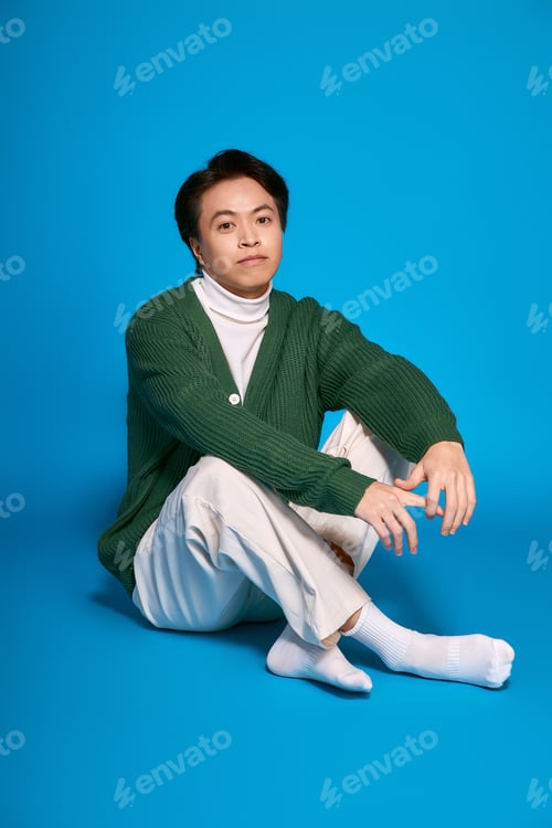 Preview: Stylish young man expressing individuality in modern studio setting with vibrant colors