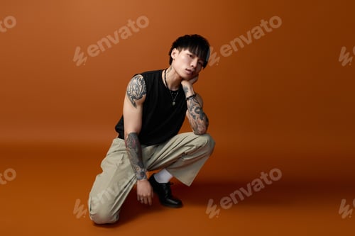 Preview: Young handsome man poses thoughtfully against a warm, rich background
