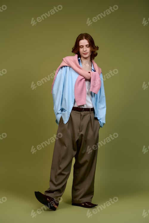 Preview: Stylish young man showcases trendy outfit in modern studio setting for fashion shoot