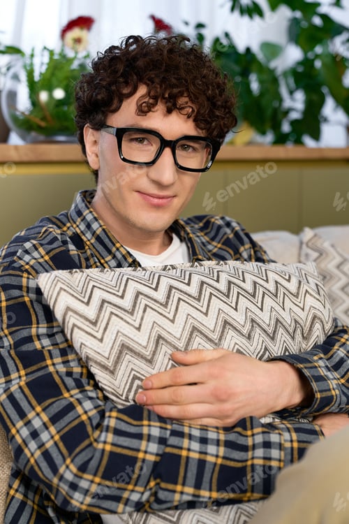 Preview: Curly man enjoys a cozy moment in his stylish, modern apartment