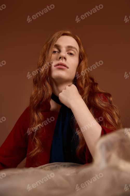 Preview: Elegant young man with long red hair showcases fashion in a stunning setting