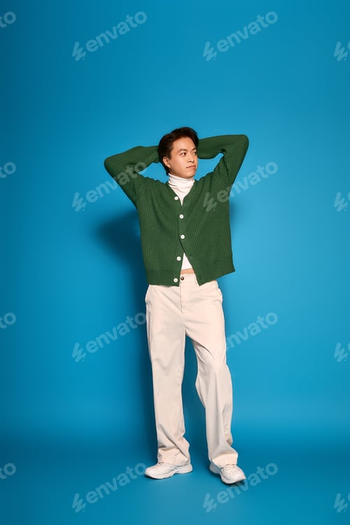 Preview: Stylish young man expresses modern fashion in a vibrant studio background