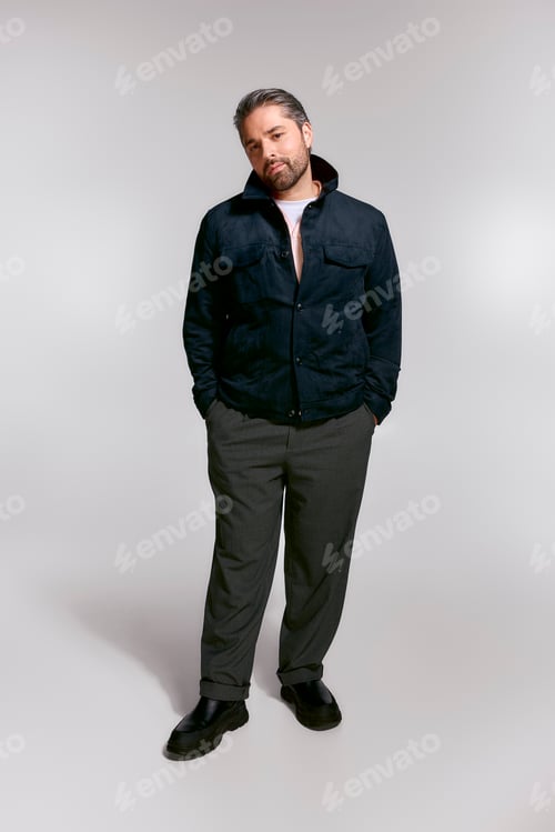 Preview: Handsome stylish man showcasing modern fashion in a minimalist studio setting