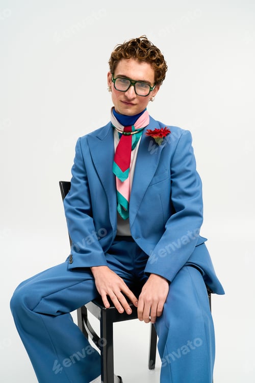 Preview: Stylish young man in trendy blue suit poses confidently in modern studio setting