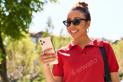 Preview: Joyful young woman enjoying her time while checking her phone