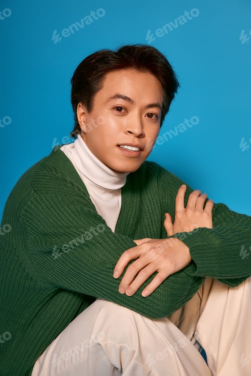 Preview: Stylish young man displays unique fashion in vibrant studio setting
