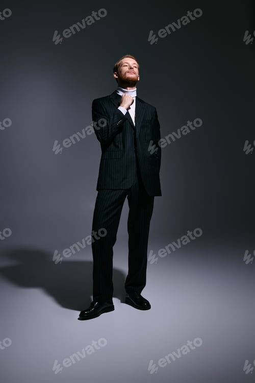 Preview: Handsome red haired man exudes charm in stylish black suit with confidence in modern setting
