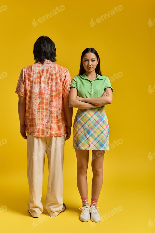 Preview: Stylish couple expressing love and individuality against a vibrant yellow backdrop