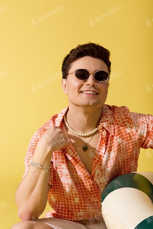 Preview: Stylish young man enjoying summer vibes with a playful attitude and trendy attire