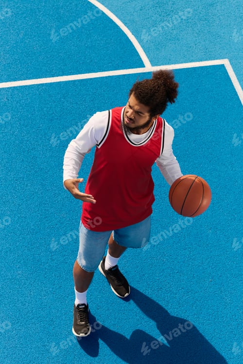 Preview: Young man displays skill and passion playing basketball outdoors in the sun