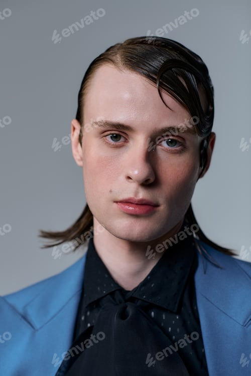 Preview: Young man showcasing modern fashion in a stylish indoor studio setting