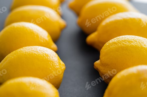 Preview: Close up view of blurred lemons in rows on black background