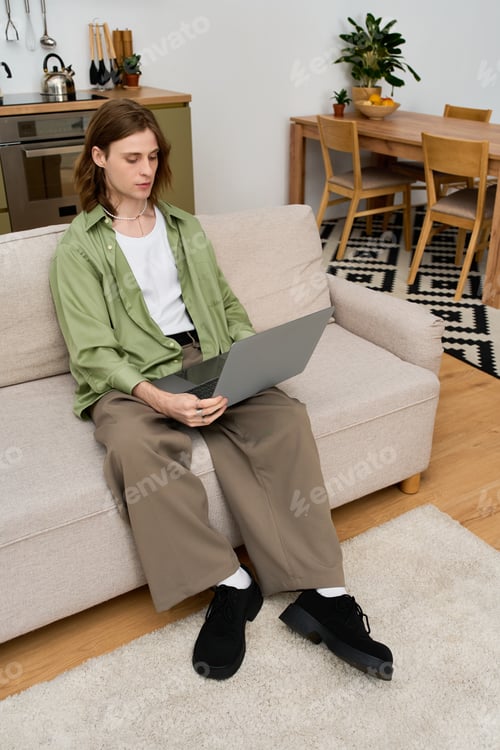 Preview: Androgynous young man enjoying time at home in a cozy modern apartment