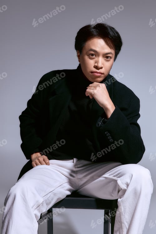 Preview: Stylish young man in a chic outfit exuding confidence in a modern studio setting