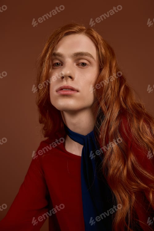 Preview: Elegant young man with long red hair showcases fashion in a stunning pose
