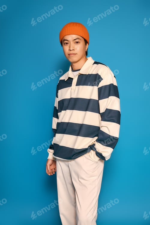 Preview: Stylish young Asian man displays unique fashion in a modern studio setting
