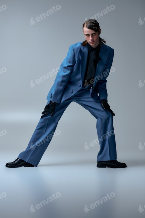 Preview: Young man showcases stylish fashion in a modern studio setting with unique pose