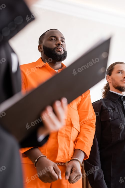 Preview: Accused African American Man in Handcuffs Standing Near Bailiff and Blurred Prosecutor With