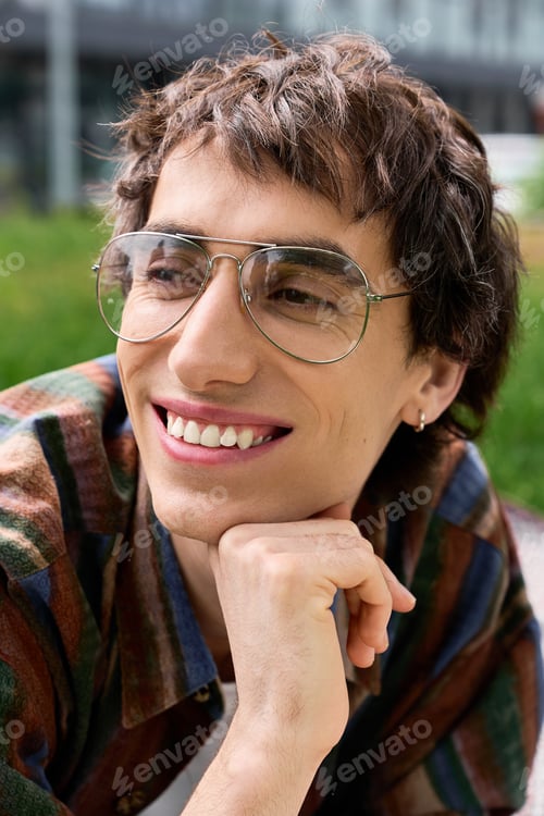 Preview: Expressing joy in nature, a non binary young man enjoys a sunny outdoor moment