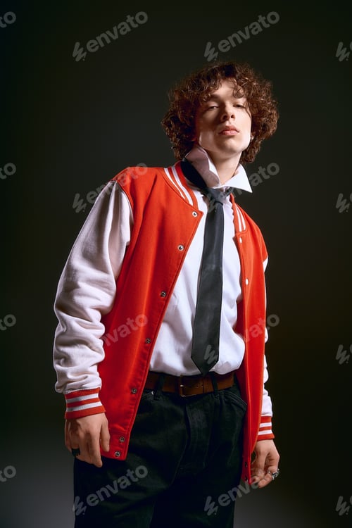 Preview: Emotional young man in stylish attire exudes charm and confidence against a dark background