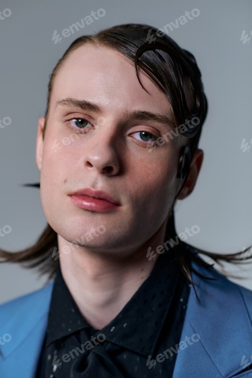 Preview: Stylish young man showcases modern fashion trends in a studio setting