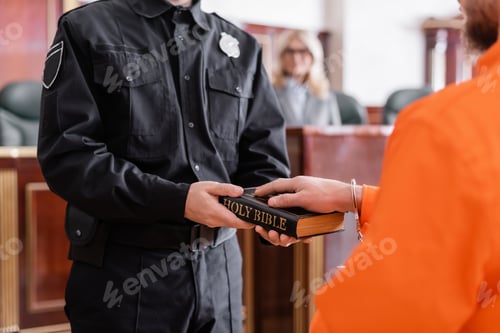 Preview: Partial View of Bailiff in Uniform Holding Bible Near Accused Man Giving Oath in Court
