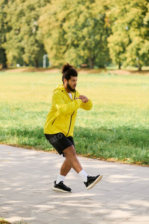 Preview: Young man in yellow windbreaker exercises outdoors on a vibrant spring day