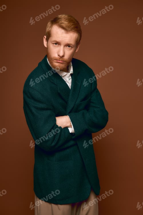 Preview: Handsome red haired man showcases unique fashion style with confident pose in a warm setting