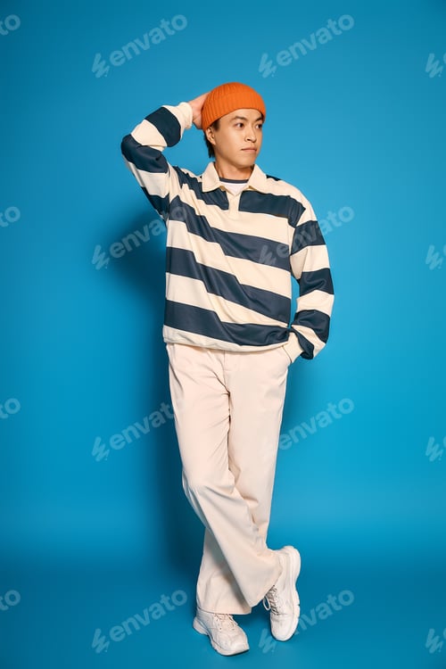 Preview: Stylish asian young man highlights modern fashion in a vibrant studio setting