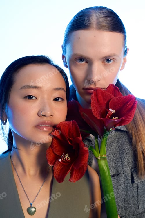 Preview: Intimate moment shared by a young couple surrounded by vibrant red flowers in a serene setting