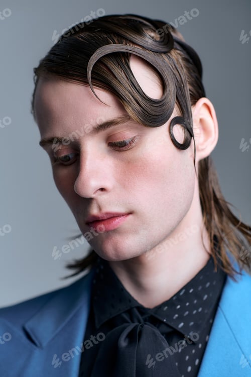 Preview: Captivating portrait of a stylish young man showcasing modern trends in a studio setting