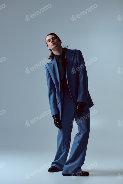 Preview: Stylish young man showcasing contemporary fashion in a sleek indoor studio setting