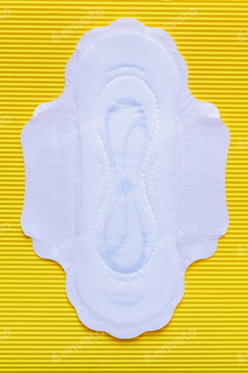 Preview: Top View of White Soft Panty Liner on Yellow Textured Background