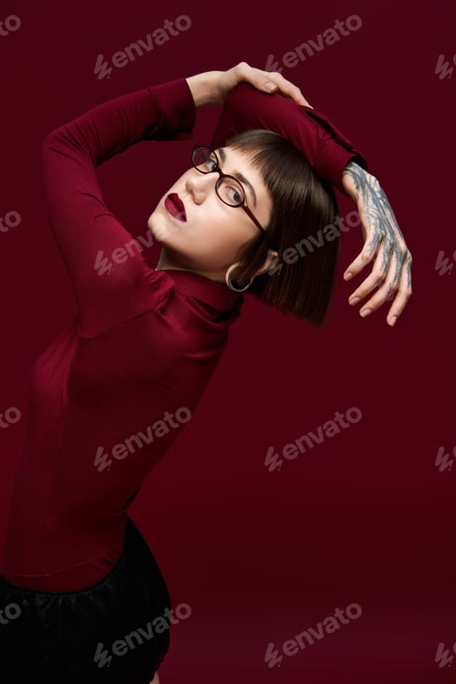 Preview: Fashion forward young woman showcases artful pose with stylish attire and bold expression